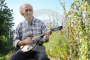 Senior man playing mandolin