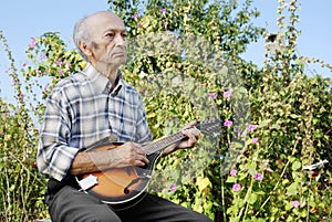 Senior man playing mandolin