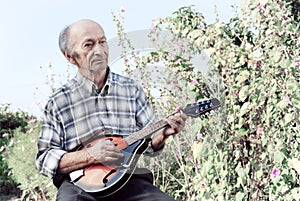 Senior man playing mandolin