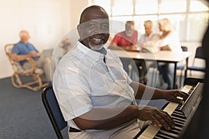 Senior man playing piano at nursing home