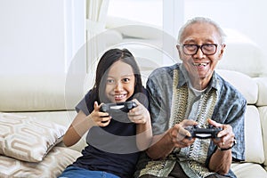 Senior man playing video games with his grandchild