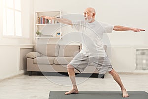 Senior man practicing yoga indoors