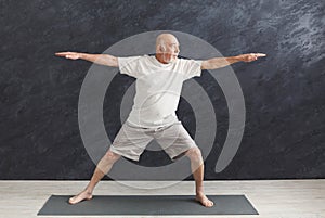 Senior man practicing yoga indoors