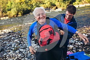 Senior man preparing for kayak tour on a mountain river