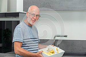 Senior man preparing meal in the kitchen