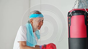 Senior man punching a boxing sack