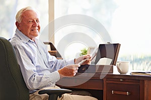 Senior Man Putting Letter Into Keepsake Box