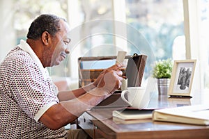 Senior Man Putting Letter Into Keepsake Box