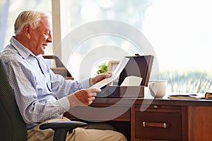 Senior Man Putting Letter Into Keepsake Box