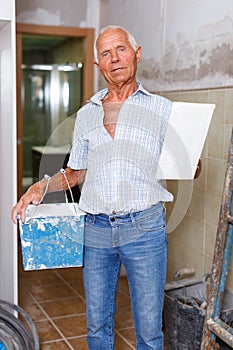 Senior man puttying walls photo