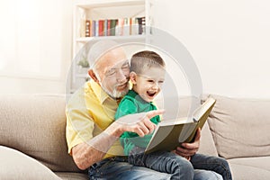 Senior man reading book for his grandchild