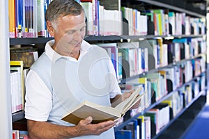Senior man reading in a library