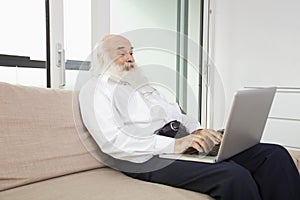 Senior man reading newspaper in house