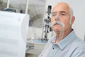 Senior man reading text during eye test