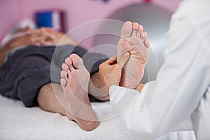 Senior man receiving foot massage from physiotherapist