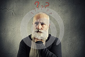 Senior man with red question marks above the head