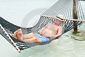 Senior Man Relaxing In Beach Hammock
