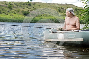 Senior man relaxing fishing from a dinghy