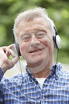 Senior Man Relaxing Listening To Music On Headphones