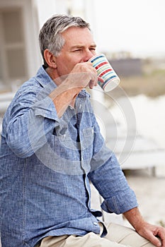 Senior man relaxing outdoors drinking coffee