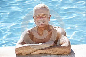 Senior Man Relaxing In Swimming Pool