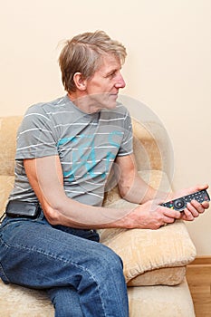 Senior man with remote control and tv-set