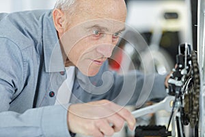 Senior man repairing bicycle wheel