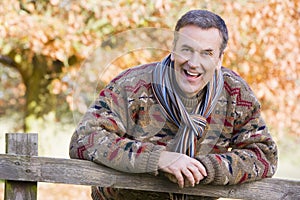 Senior man resting on fence