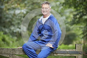 Senior Man Resting Whilst Exercising In Countryside