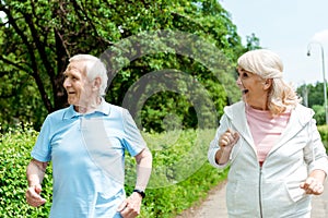 Senior man and retired woman running in park