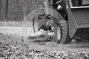 Senior man rides tractor on edge of rocky path