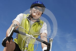 Senior Man Riding Bicycle Against Sky