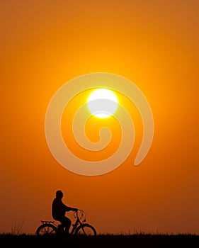 Senior man riding bicycle at sunset