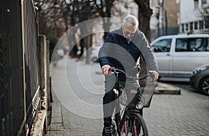 Senior man riding bicycle on urban street, active lifestyle concept.