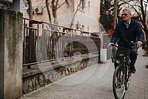 Senior man riding bicycle on urban street, active lifestyle concept.