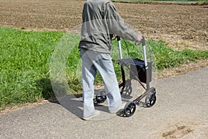 senior man with rollator in countryside of south germany