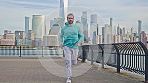 Senior man running sprinting on road. Fit male fitness runner workout and run in NYC background. Mature man running on