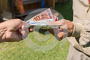 Senior man`s hands holding Euro banknote. Struggling pensioners