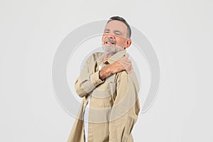 Senior man with shoulder pain expression on white
