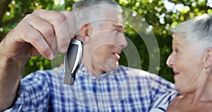 Senior man showing car key to senior woman