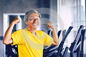 Senior Man showing off muscle for strong healthy lifestye concept in a fitness gym photo