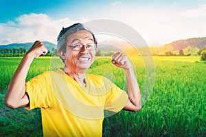 Senior Man showing off muscle for strong healthy lifestye concept in a nature farming field background photo