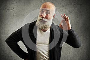 Senior man showing ok sign and looking at camera