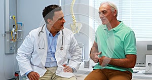 Senior man showing stomach ache pain to doctor