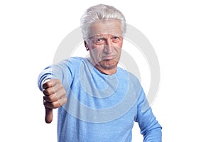 Senior man showing thumbs down on white background