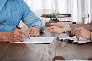 Senior man signing document with lawyer