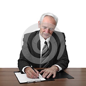 Senior man sits at table and writes document