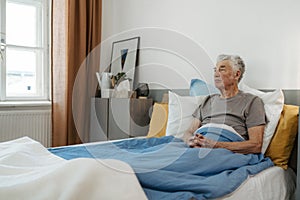 Senior man sitting alone in his bed, concept of loneliness and mental health.