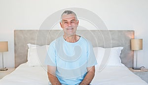 Senior man sitting on bed