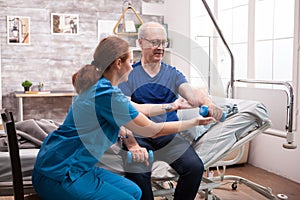 Senior man sitting on bed doing physiotherapy